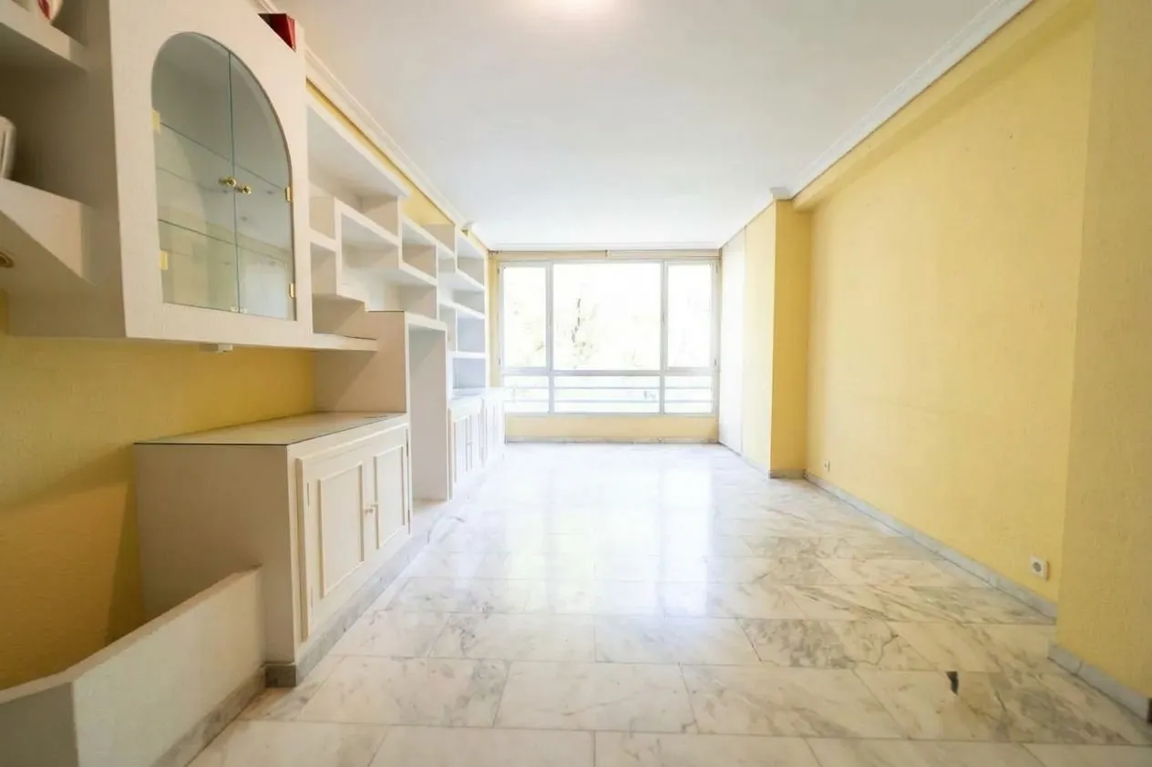Salón vacío, paredes amarillas y suelo de mármol: la vivienda tal como está hoy